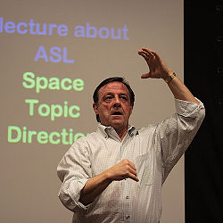 (CC) Photo: Nick Thompson   A lecture in American Sign Language. Phonology and linguistics generally involve the study not just of speech but also sign language; the same system used to represent language, whether by sound or sign, is widely viewed as underlying both. Research into sign language also benefits from the insights of linguists who are themselves native signers.