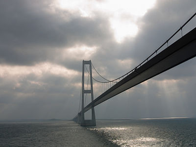 The Øresund Bridge at evening with beams of light shining through the clouds.