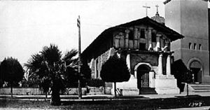 (PD) Photo: William Amos Haines Mission San Francisco de Asís around 1910. The wooden addition has been removed and a portion of the brick Gothic Revival church is visible at right. The large stone church was severely damaged in the 1906 earthquake.[2]