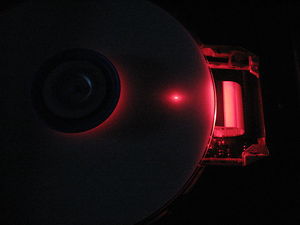Picture of a DVD with a pink light to one side.