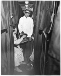 © Photo: Atchison, Topeka and Santa Fe Railway A Pullman porter accepts a pair of boots to be polished from a soldier in a sleeping berth aboard an Atchison, Topeka and Santa Fe Railway military train.