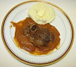 Osso buco served with garlic mashed potatoes and a strained, puréed sauce