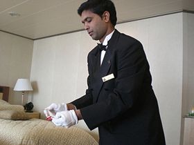 A butler serving vacationers aboard the cruise ship Queen Victoria, 2008.